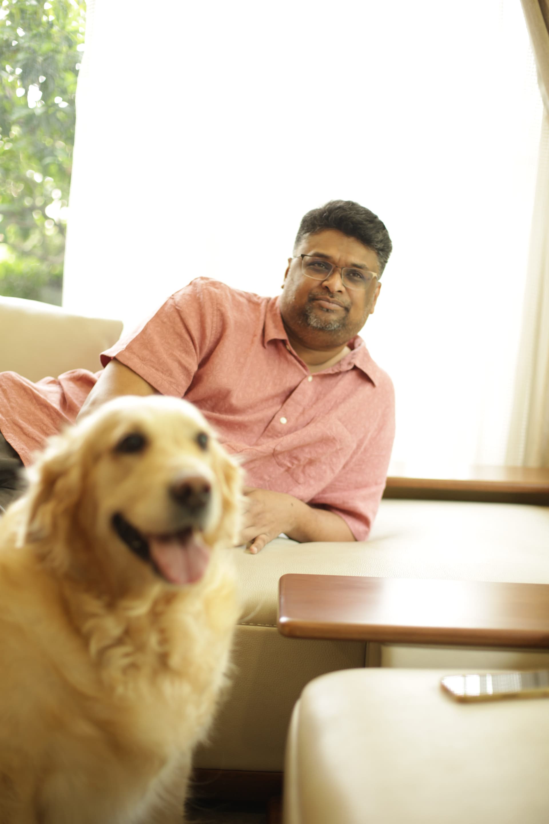 Hussain Sha Kiran relaxing indoors with a golden retriever